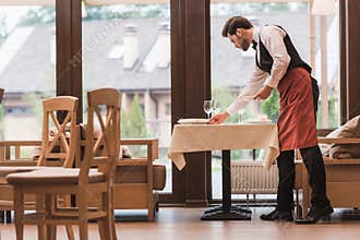 Waiter serving plates on table