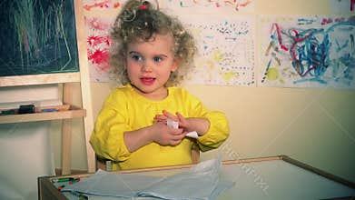 Cute little girl tearing paper book. Bored child