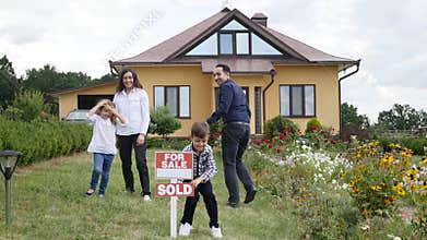 Happy family in front of their new house