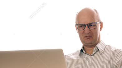 Businessman in glasses working at laptop saw disgusting image. Man made an expression of disgust while working in office