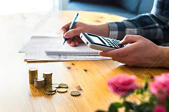 Man using calculator and counting budget, expenses and savings.