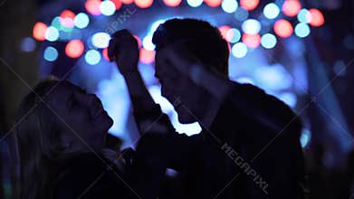 Man and woman hanging out at music festival, enjoying night life, relaxation