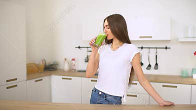 Green detox smoothie - healthy woman drinking vegetable smoothie. Happy young woman drinking fresh green juice enjoying