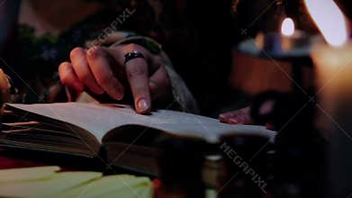 Experienced witch reading spellbook, magic atmosphere and attributes, wizardy