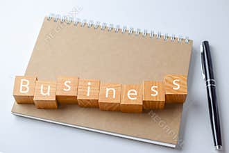 Wood block with business word on Notebook with pen
