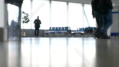 People walking through an airport terminal with suitcases, bags and baggage
