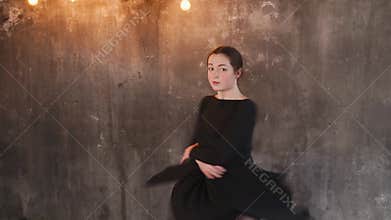 Dancing woman in black dress indoor