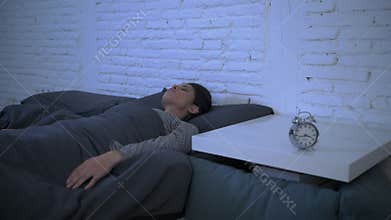 Lateral panning shot of young attractive hispanic woman upset in stress and insomnia lying anxious on bed and trying to sleep