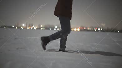 Close-up of woman`s feet walking on the snow desert at night . Stabiblized slow-motion shot moon light
