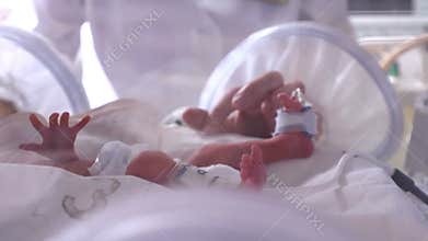 Maternity centre. .Severely ill newborn in incubator, intensive hospital therapy: CCU, ICU, ITU. The tiny baby child