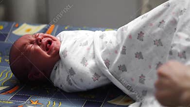 Asian newborn baby smiling when swaddle her body with Diapers after taken shower.