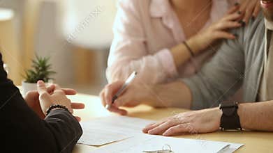 Couple signing document, handshaking realtor, getting keys of new home