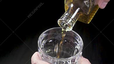 Man pouring whiskey into a glass from a carafe