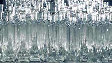 Many glass bottles are placed on a assembly line at a plant. 4K.