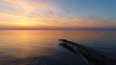Aerial view of beautiful sunrise over the sea water and old bridge video