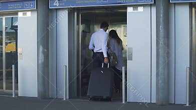 Young couple entering elevator at the airport, business trip, travel and tourism