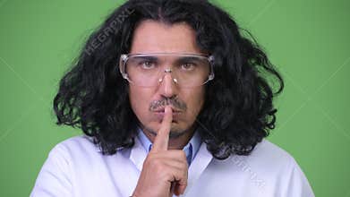Crazy scientist with finger on lips