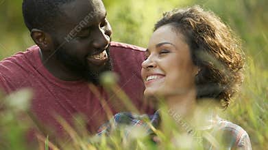 Loving couple relaxing outside on picnic in city park, having fun together