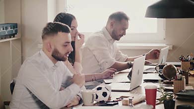 Happy young European business people sit by the table, work together with laptops in modern healthy office, slow motion.