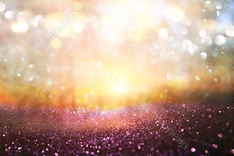 blurred abstract photo of light burst among trees and glitter golden bokeh lights.