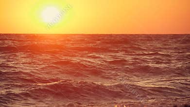 Big waves on a sea beach at sunset. Beautiful waves of slow motion video on the background of the orange sun