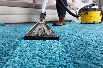 Person Using Vacuum Cleaner For Cleaning Carpet