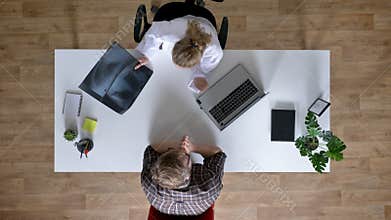 Young woman doctor is showing x-ray scan to patients and explaining disease, man at doctor, medical concept, top shot