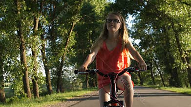 Cute blond teenage girl on bicycle trip in summer