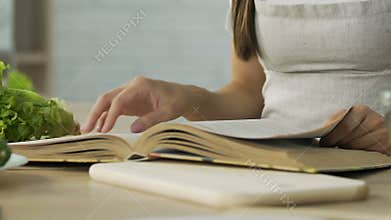 Woman reading old grannys recipes book at home exquisite dinner, ingredients