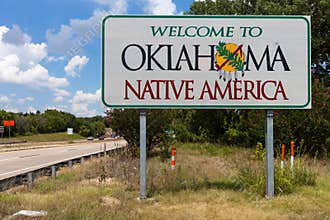 Welcome to Oklahoma sign with blue sky and trees in the background