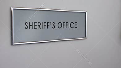Sheriff office door, hand knocking, law enforcement officer, crime prevention