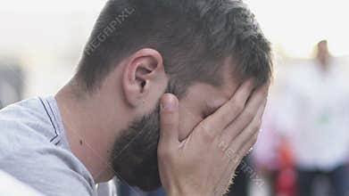 Disappointed man sitting in street confused, looking for way out of situation