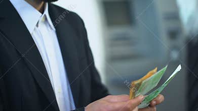 Man counting euros in bank branch, interest on deposit, profitable investment