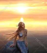 An amazing golden-haired mermaid on the stone in the evening lights of sun