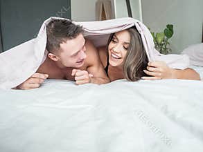 Hotel, travel, relationships, and happiness concept happy couple in bed.