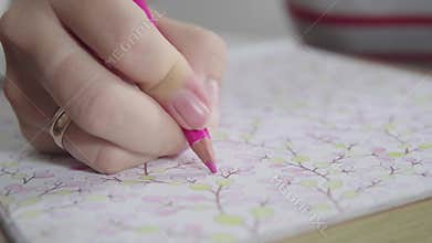 Color video of a woman hand holding a pencil drawing and coloring coloring book. Activity for relaxing and concentrate