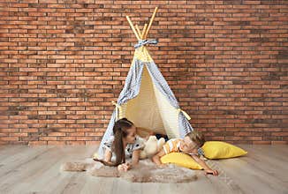 Playful little children in handmade tent