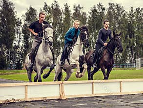 23.08.2017 Smolensk Region show jumping at the festival. Three riders jumping on horseback synchronously over an obstacle.