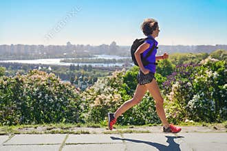 Woman runner run commutes to work with backpack, city morning run commuting and fitness concept