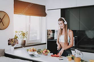Girl Is Cooking And Listen To Music In Headphones