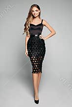 Elegant pretty woman in black night out dress and high heels.