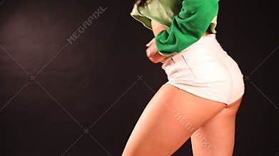 Woman dancing booty twerk sitting on the floor on a blue background