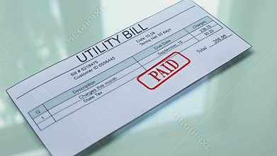 Utility bill paid, hand stamping seal on document, payment for services, tariff