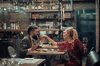 Seducing beautiful woman looking at her lover with wine glass. Having romantic talk.