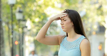 Woman suffering head ache in the street