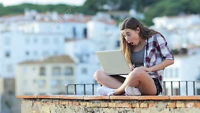 Surprised teen finding amazing content on a laptop