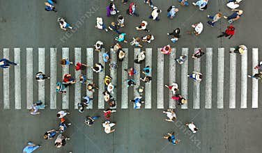 Aerial. Pedestrians passing a crosswalk. Rush hour in the city. People are rushing to work.