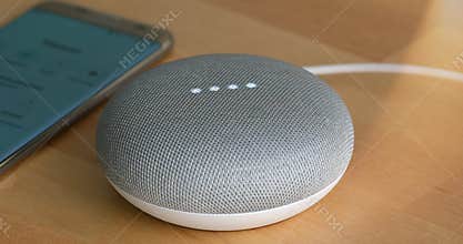 Paris, France - December 17 2018: Google Home Mini On The Wooden Table Chalk Color. Smart Speaker With The Google Assistant, Vir