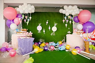 Birthday party concept, decorations for sweet party. Huge number one, table with sweets and desserts, cloud from balloons and ice-