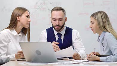 Attractive fashion male boss spending team meeting with two female colleagues businesswoman
